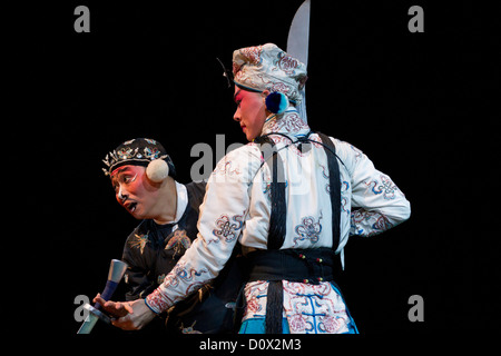 Two male characters jousting in traditional costumes during a performance of Peking Opera for tourists at a theatre in Beijing Stock Photo