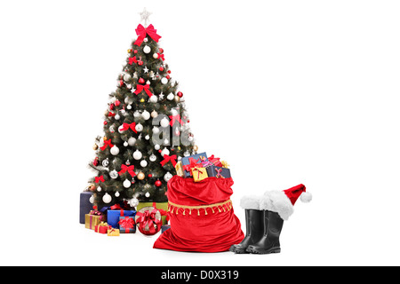 Christmas tree amd santa accessories, pair of boots and bag full of presents isolated against white background Stock Photo