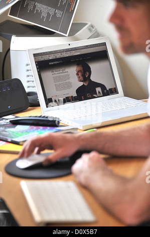 Web and graphic Graphic Designer Rob Gwilliam working from home using broadband wifi in Herefordshire Stock Photo