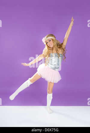 Children fashiondoll spring girl dancing on purple background Stock Photo