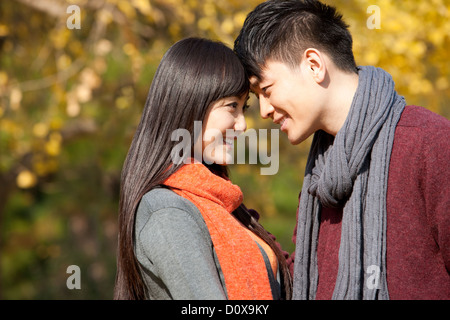 Sweet young couple in love face to face outdoors in autumn Stock Photo