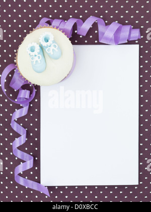 muffin with blue slippers in corner white frame paper decorative and purple ribbon Stock Photo