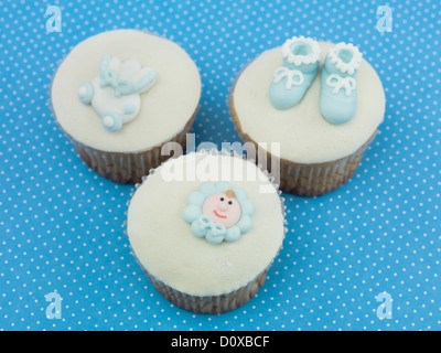 three muffins for newborns with blue decorations on blue background with dots  Stock Photo