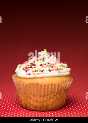 muffin with colorful candy on the table red with white dots Stock Photo