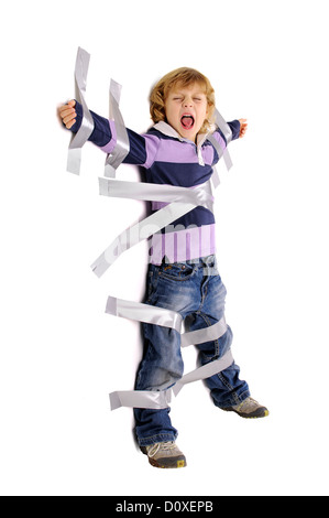 Young angry boy glued to the wall with duct tape Stock Photo