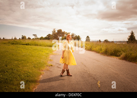 Young woman standing on rural path Stock Photo