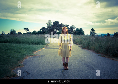 Young woman standing on rural path Stock Photo