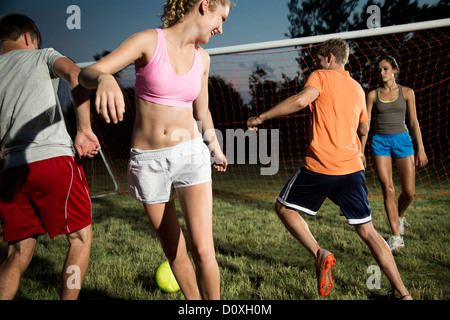 Friends playing soccer at night Stock Photo