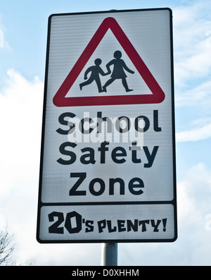 A traffic sign that warns of the 'school safety zone' and instructs driver's to keep to maximum of 20 miles per hour. Stock Photo