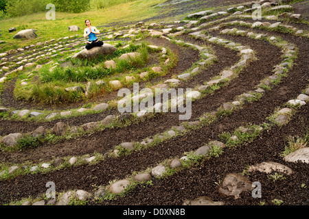 Woman meditating in stone labyrinth Stock Photo