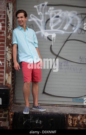 Young man standing in front of graffiti, portrait Stock Photo