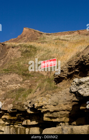 Warning sign post for dangerous cliffs, Filey Brigg, North Yorkshire, England Stock Photo