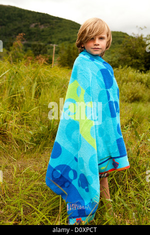 Boy wrapped in a towel outdoors Stock Photo