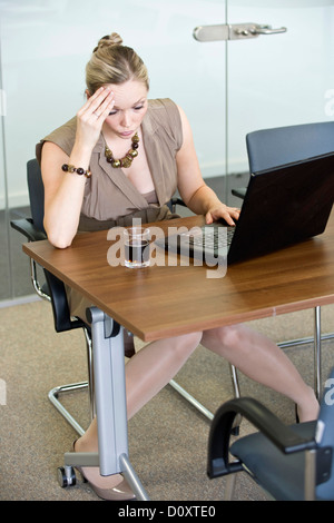 Female office worker looking fed up and stressed. Stock Photo