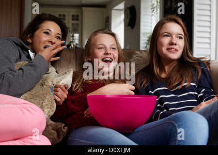 Teenage girls watching movie with popcorn Stock Photo