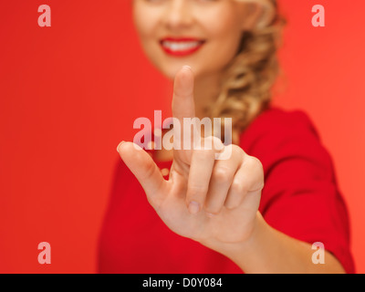 woman in red dress pressing virtual button Stock Photo
