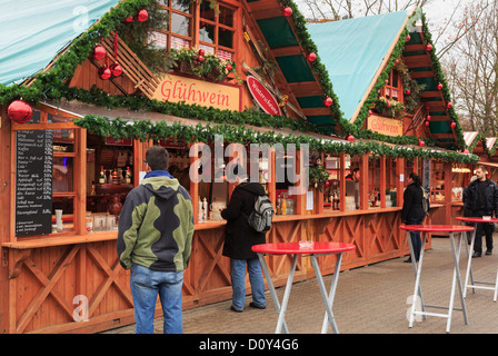 Customers buying at a Christmas market stall selling drinks and traditional warm Gluhwein at Alexanderplatz, Berlin city, Germany Stock Photo