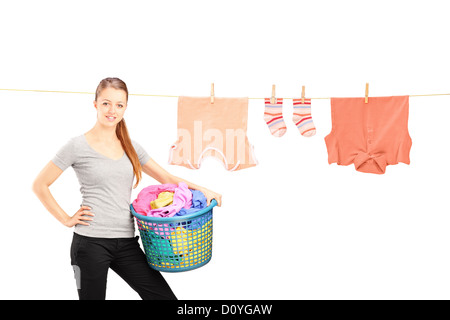 Smiling woman holding a laundry basket and a laundry line with clothes isolated on white background Stock Photo