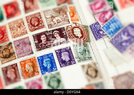 Old stamp album with British stamps focused on King George VI, UK Stock Photo