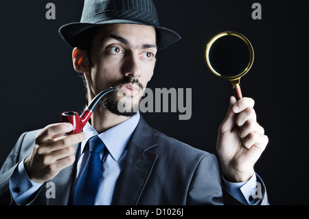 Young detective with pipe and magnifying glass Stock Photo - Alamy