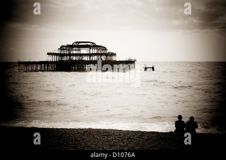 Couple sat on Brighton beach, pin hole effect Stock Photo