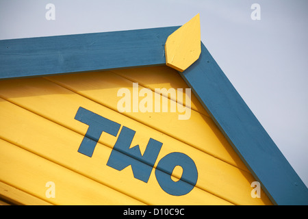 Detail of yellow and blue beach hut number Two at Calshot, near Southampton, Hampshire UK in November Stock Photo