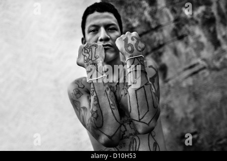 A member of the 18th Street Gang (M-18) proudly shows off his gang tattoos in San Salvador, El Salvador. Stock Photo