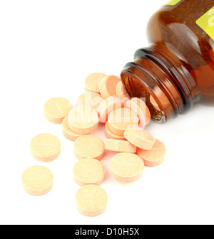 pills of vitamin C spilled out open container on white background Stock Photo