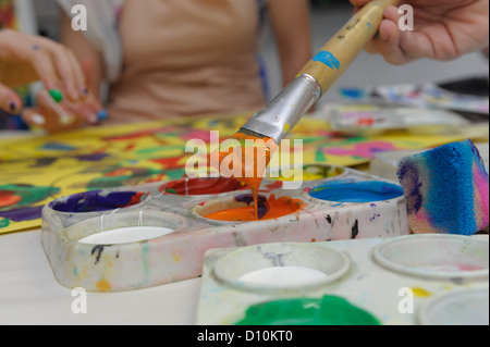 Paintbrush dipped in orange paint Stock Photo