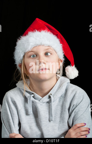 A girl in a Christmas hat pulling a funny face Stock Photo