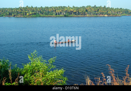 Small wooden canoe boat sailing through the Kerala Backwaters at India Wide Angle Scenery view Stock Photo