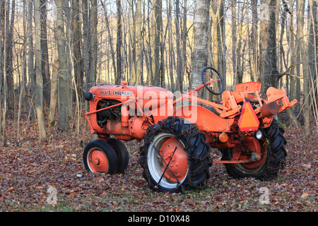 An old Allis-Chalmers tractor sits idle next to a woodlot. Stock Photo