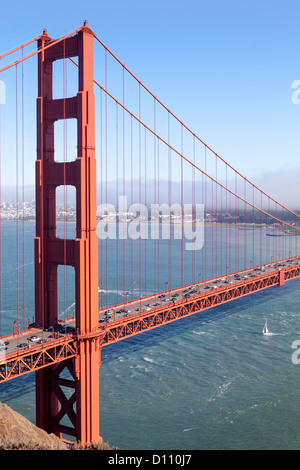 The San Francisco Golden Gate Bridge, pedestrians walking across the bridge, cars driving across and boats sailing in the bay. Stock Photo