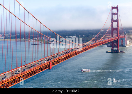 The San Francisco Golden Gate Bridge, pedestrians walking across the bridge, cars driving across and boats sailing in the bay. Stock Photo