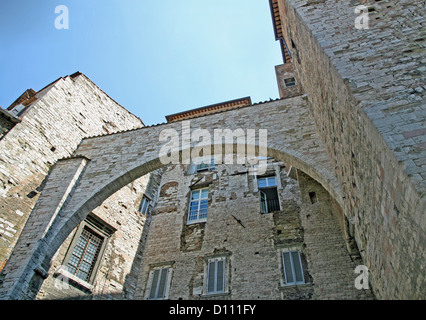 ancient Etruscan arch made of lime and brick between the medieval houses Stock Photo