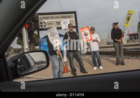 Dec. 4, 2012 - Los Angeles, California (CA, United States - Striking workers walk with a picket outside the Port of Los Angeles Tuesday December 4, 2012 in Los Angeles, California. The strike was launched last Tuesday by the 800-member International Longshore and Warehouse Union Local 63 Office Clerical Unit, which had been working without a contract since June 30, 2010. With some 10,000 ILWU members honoring the strikers' picket lines, the action has shut down 10 of the 14 cargo container terminals at the complex. At least 11 ships have diverted cargo to other ports, including in Mexico, sinc Stock Photo