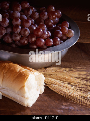 STILL LIFE OF WHEAT BREAD AND GRAPES IN A SILVER BOWL SYMBOLIC OF COMMUNION Stock Photo