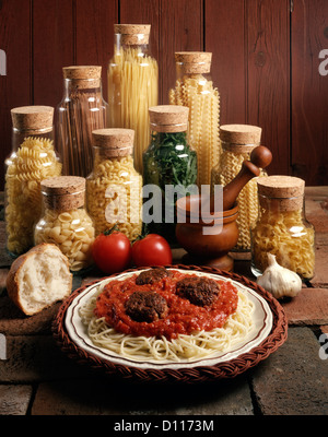 1980s DISH OF SPAGHETTI AND MEATBALLS WITH JARS OF PASTA NOODLES Stock Photo