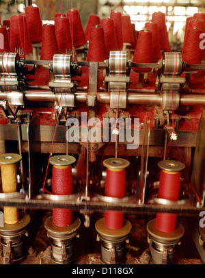 1970s SPOOLING RED WOOL IN TEXTILE FACTORY Stock Photo