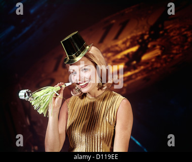 1960s YOUNG BLONDE WOMAN LOOKING AT CAMERA WITH PARTY HAT NOISEMAKER HORN SMILING NEW YEAR CLOCK BACKGROUND Stock Photo