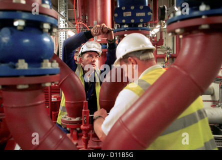 Two workers working as a team Tightening valves using a spanner Stock Photo