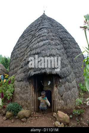 Kid At The Door Of A Dorze Tribe House Made Of Wood Poles And Woven Bamboo, Chencha, Ethiopia Stock Photo