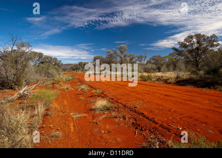 Red outback road through native bushland and under blue sky at Gundabooka National Park, north-western NSW Australia Stock Photo