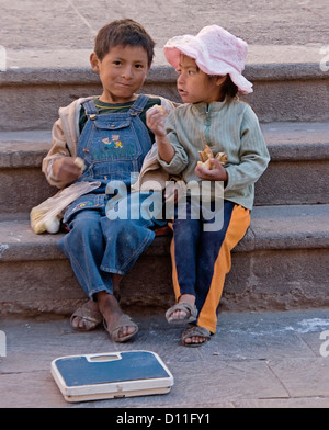 Street children with food and scales in city of Ayacucho Peru South America Stock Photo