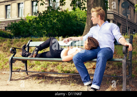 Romantic young couple resting on the park bench together Stock Photo