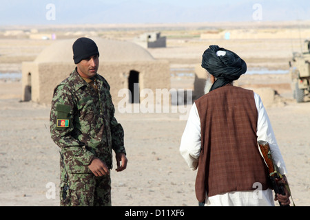 An Afghan National Army soldier speaks with an Afghan Local Police recruit in Farah province, Dec. 4. The ALP recruits participated in patrolling class as part of their training to be certified to provide security to the people of their villages. Stock Photo