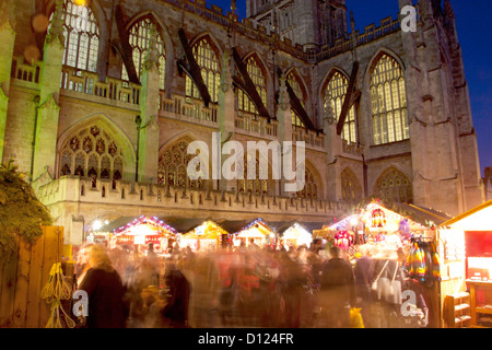 Christmas Market stalls with Bath Abbey in the background at night / twilight / dusk Bath Somerset England UK Stock Photo