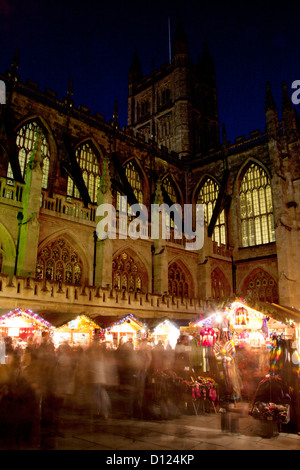 Christmas Market stalls with Bath Abbey in the background at night / twilight / dusk Bath Somerset England UK Stock Photo