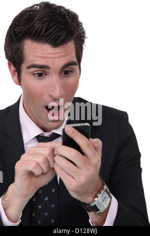 Shocked businessman reading text message Stock Photo