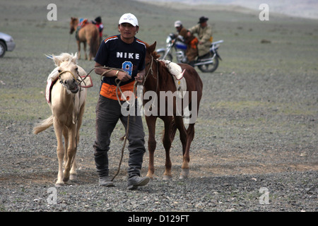 Man leading horses at the Naadam festival horse races, Chandmani Stock Photo